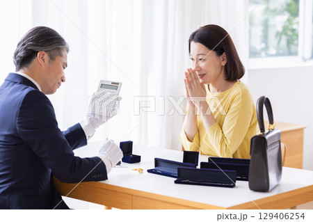 出張買取　自宅で査定をしてもらっている主婦 129406254