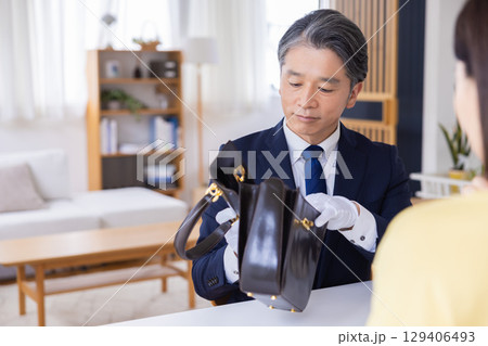 出張買取 査定 訪問先で鑑定をしている男性 出張買取 査定 訪問先で鑑定をしている男性 129406493