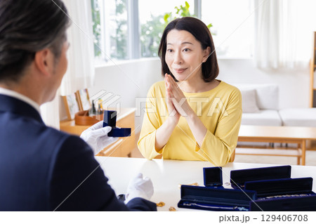 出張買取　自宅で査定をしてもらっている主婦 129406708