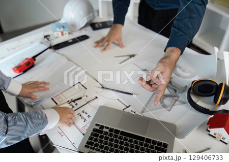 Engineers and architects collaborate on blueprint designs in modern office environment with innovative ideas Engineers and architects collaborate on blueprint designs in modern office environment with innovative ideas 129406733