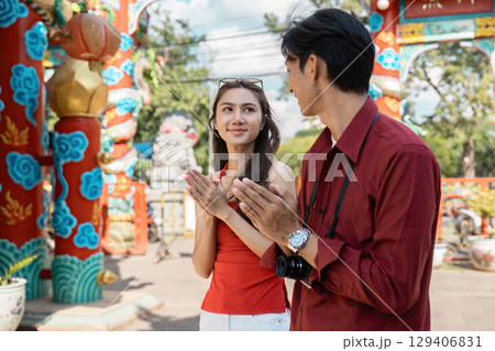 Celebrating chinese new year young couple enjoys festivities at colorful temple outdoor scene joyful atmosphere engaging perspective Celebrating chinese new year young couple enjoys festivities at colorful temple outdoor scene joyful atmosphere engaging perspective 129406831