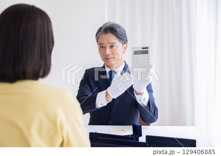 出張買取 査定 訪問先で鑑定をしている男性 出張買取 査定 訪問先で鑑定をしている男性 129406885