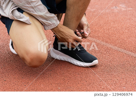 Athlete preparing for race outdoor track action shot competitive environment close-up view focus on readiness Athlete preparing for race outdoor track action shot competitive environment close-up view focus on readiness 129406974