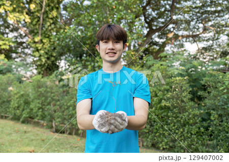 Young Volunteer Planting Tree in Park for Environmental Conservation and Community Service Young Volunteer Planting Tree in Park for Environmental Conservation and Community Service 129407002