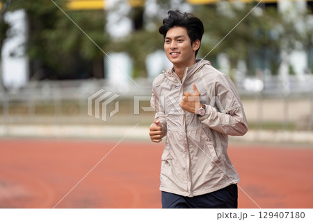 Energetic Young Man Jogging Outdoors in Sportswear for a Healthy Lifestyle and Fitness Routine Energetic Young Man Jogging Outdoors in Sportswear for a Healthy Lifestyle and Fitness Routine 129407180