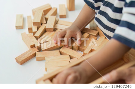 Child Development. Close-up of toddler's hands playing with wooden blocks. Child Development. Close-up of toddler's hands playing with wooden blocks. 129407246