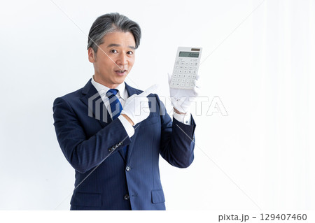 買取業者　鑑定士　白手袋をして電卓を持っている男性 129407460