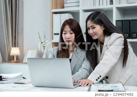 Professional Businesswomen collaboration in Modern Office Environment with Laptop and Documents Professional Businesswomen collaboration in Modern Office Environment with Laptop and Documents 129407492