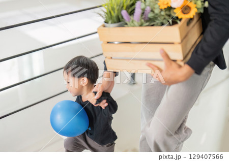 Father and son bonding while unpacking boxes at home 129407566