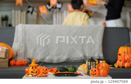 Halloween Fun. A mother and son decorating their living room with festive items. Halloween Fun. A mother and son decorating their living room with festive items. 129407569