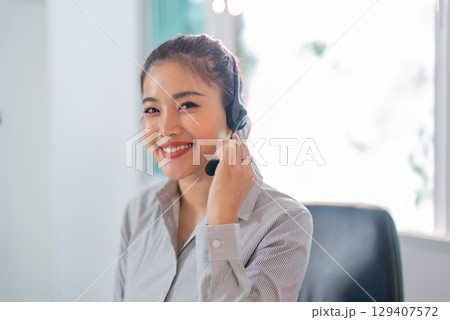 Remote Work. Happy woman in headset smiling while providing customer support. 129407572