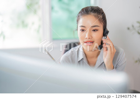 Remote Work. Focused woman in headset providing customer service in office. Remote Work. Focused woman in headset providing customer service in office. 129407574