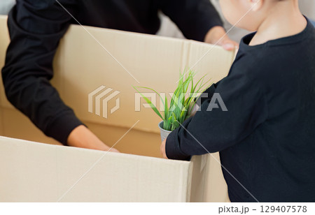 Child Helping Father with Unpacking: A Family Moment 129407578