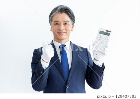 買取業者　鑑定士　白手袋をして電卓を持っている男性 129407583