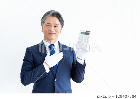 買取業者　鑑定士　白手袋をして電卓を持っている男性 129407584