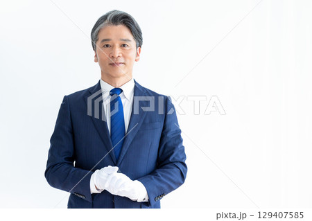 買取業者　鑑定士　白手袋をして電卓を持っている男性 129407585