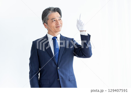 買取業者　鑑定士　白手袋をして電卓を持っている男性 129407591