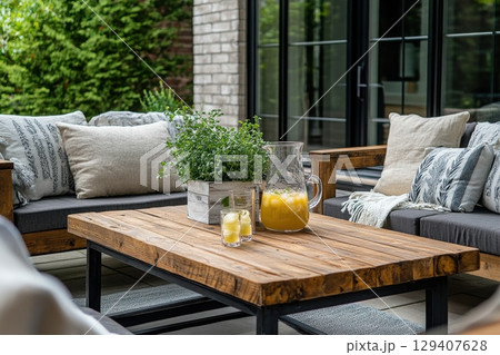 Relaxing outdoor lounge area with refreshing drinks cozy furniture natural surroundings summer vibes inviting atmosphere for gatherings 129407628