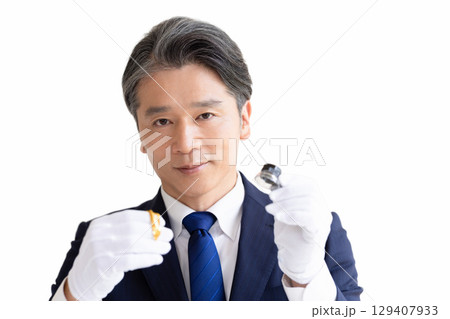 出張買取　貴金属の査定をしている男性 129407933
