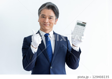 買取業者　鑑定士　白手袋をして電卓を持っている男性 129408135