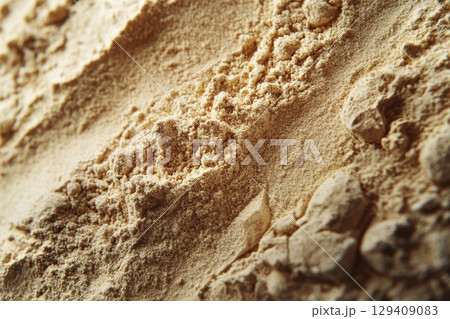 A close up of a pile of sand with a few rocks mixed in 129409083