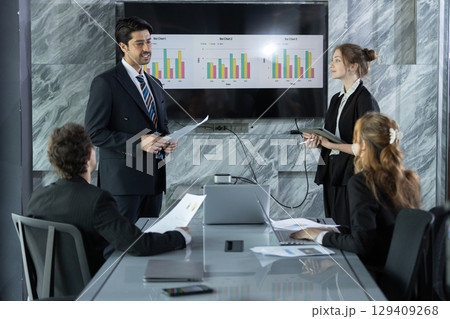 Business professionals in modern conference room presenting data charts during a meeting, discussing strategies and analyzing performance for corporate growth and success. Business professionals in modern conference room presenting data charts during a meeting, discussing strategies and analyzing performance for corporate growth and success. 129409268