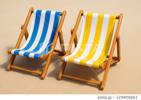 Two classic striped beach chairs, blue and yellow, ready for summer vacation and relaxation 129409881