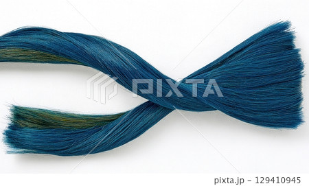 Twisted strand of vibrant blue and green thread for textile and crafting uses 129410945