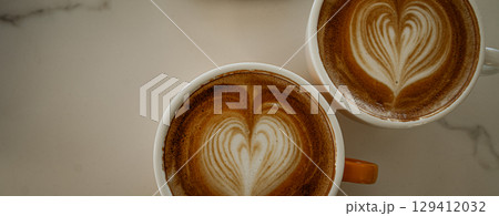 Cups of coffee decorated with a heart 129412032
