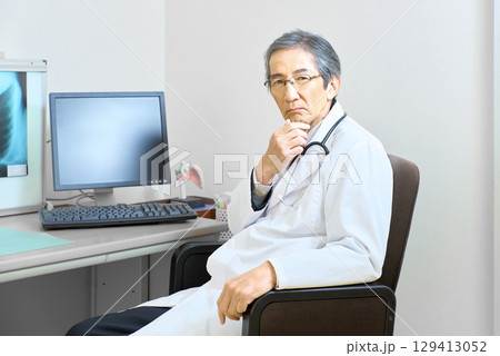 診察室に座るシニア医師 診察室に座るシニア医師 129413052
