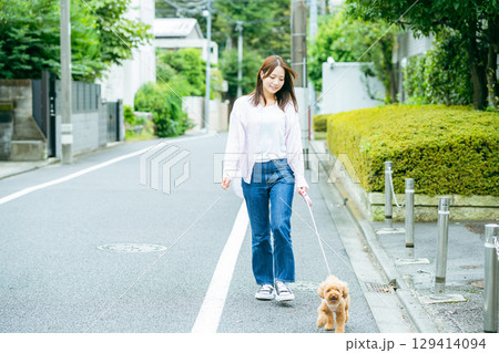 ペットと散歩する若い女性	 129414094