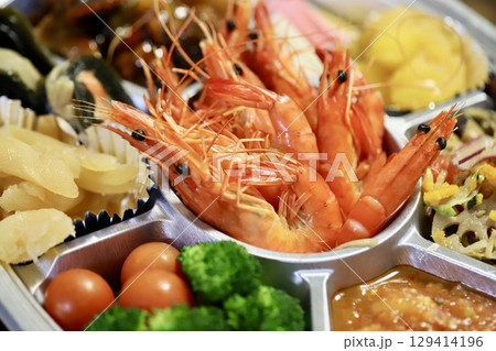 使い捨てトレーに入れた正月用オードブル 129414196