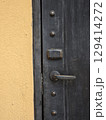 close up view of rustic door lock and electronic access panel on textured wall, showcasing blend of traditional and modern security features 129414272