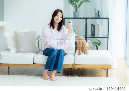 部屋でペットとくつろぐ若い女性 部屋でペットとくつろぐ若い女性 129414402