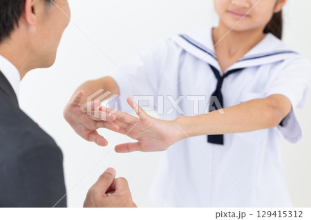 お父さんを嫌がる学生服を着た中学生の女の子 129415312