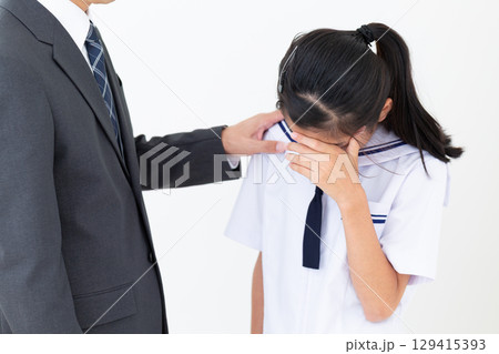 泣いて落ち込む中学生の娘を慰めるお父さん 129415393