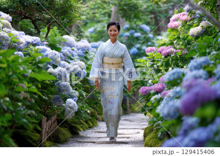 紫陽花の咲く小道を歩く着物を着た女性 129415406