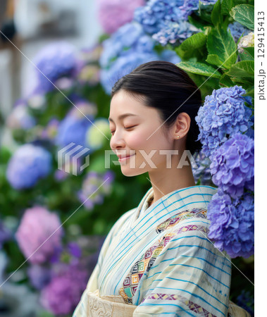 アジサイを背景にした着物姿の若い女性 129415413