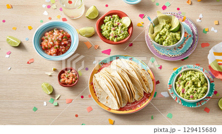 Cinco de Mayo tacos presented with traditional Mexican garnishes, background 129415680