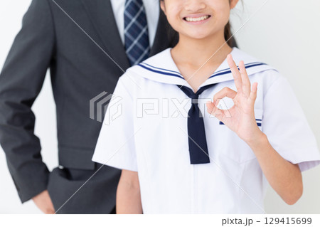 笑顔で丸サインをする夏の学生服を着た中学生の女の子とスーツ姿のお父さん 129415699