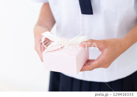 プレゼントを持つ夏の学生服姿の中学生女子 プレゼントを持つ夏の学生服姿の中学生女子 129416333