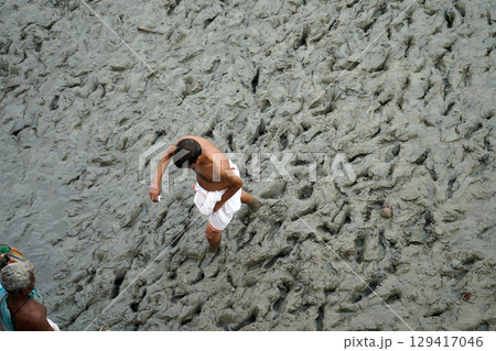 14th October 2023, Babughat, Kolkata, West Bengal, India. Man Crossing Muddy Riverbank During Low Tide 14th October 2023, Babughat, Kolkata, West Bengal, India. Man Crossing Muddy Riverbank During Low Tide 129417046