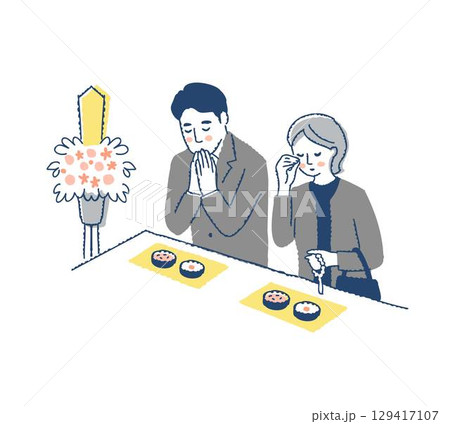 お葬式で焼香台に立つ喪服の男女 129417107