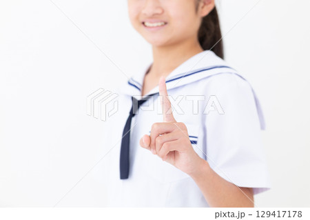 人差し指を立てる夏の学生服姿の中学生女子 129417178