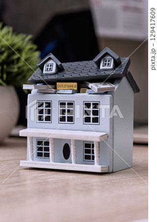 Mini house with cash and gold inside roof 129417609