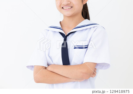 腕組みをして微笑む夏の学生服姿の中学生女子 129418975