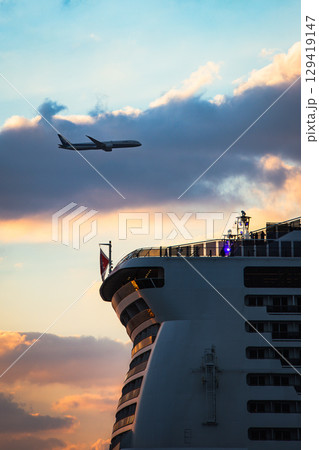 夕日の飛行機と船 129419147
