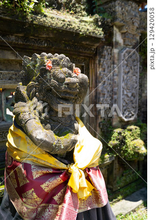 バリ島ヒンドゥー寺院の花飾りをつけた守護像 129420058