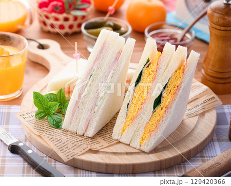 朝食やランチにぴったりのミックスサンドイッチとオレンジジュース　カフェ風おしゃれ盛り付け 129420366