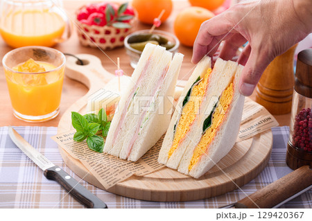 朝食やランチにぴったりのミックスサンドイッチとオレンジジュース　カフェ風おしゃれ盛り付け 129420367